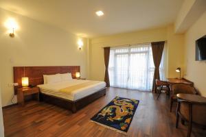a hotel room with a bed and a window at Eutsholing Boutique Hotel in Thimphu