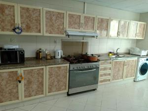 a kitchen with a stove and a microwave at 22 R3 Luxury Room in a 4-bedroom apartment with private washroom outside the room ### 22 R3 غرفة فاخرة في شقة 4 غرف نوم مع حمام خاص خارج الغرفة ### in Ajman 