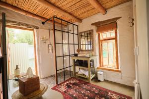 a room with a room with a mirror and a rug at Olive Stone Farm Cottages in Montagu