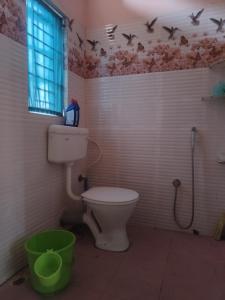 uma casa de banho com WC e pássaros no tecto em Tales of Guwahati em Guwahati