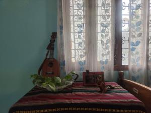ein Zimmer mit einem Bett mit Gitarre darauf in der Unterkunft Tales of Guwahati in Guwahati