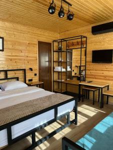 ein Schlafzimmer mit einem Bett, 2 Tischen und einem TV in der Unterkunft Hotel Eurica in Kutaissi