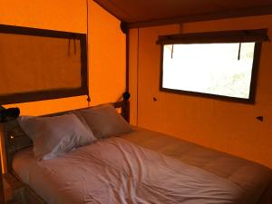 Cama en habitación con ventana en Bungalows - Càmping El Solsonès, en Solsona