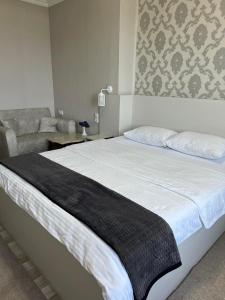 1 dormitorio con 1 cama grande y 1 sofá en Hotel Eurica, en Kutaisi