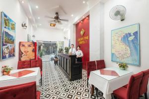 due persone in piedi al bancone di un ristorante di Golden Time Hostel 3 a Hanoi