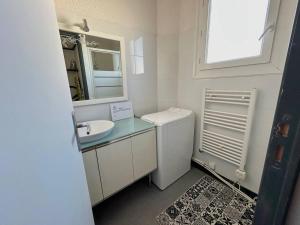 Baño blanco con lavabo y espejo en Appartement Argelès-sur-Mer, 2 pièces, 4 personnes - FR-1-388-222 en Argelès-sur-Mer
