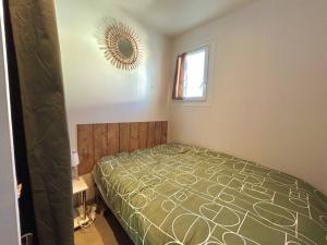 1 dormitorio con cama y espejo en la pared en Appartement Argelès-sur-Mer, 2 pièces, 4 personnes - FR-1-388-222 en Argelès-sur-Mer