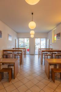 een eetkamer met houten tafels en stoelen bij Locarno Youth Hostel in Locarno