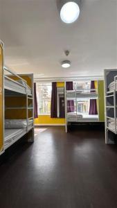 a room with three bunk beds in a building at Safestay Edinburgh Cowgate in Edinburgh