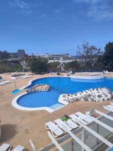 uma piscina com espreguiçadeiras e uma piscina em Olga Paraiso del Sur em Playa Paraiso