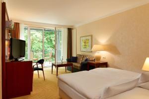um quarto de hotel com uma cama e uma televisão em Grand Hotel Binz em Binz