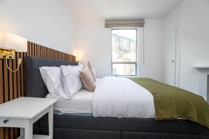 a bedroom with a bed with white sheets and a window at 3 bedroom house in Notting Hill in London