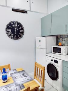 a kitchen with a dishwasher and a clock on the wall at Riviera Beach A in Praia da Vitória