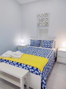 a bedroom with a bed with a yellow and blue comforter at Riviera Beach A in Praia da Vitória +15 photos