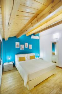 a bedroom with a large bed with a blue wall at Ciuriddu Appartamenti in Castellammare del Golfo