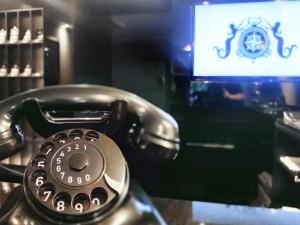 ein Telefon auf einem Schreibtisch mit einem TV in der Unterkunft Villahotel Rheinblick in Köln