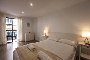 a white bedroom with a large bed and a window at Apartamentos Turísticos Puerto Cartago by CartagenaSpain in Cartagena +10 photos