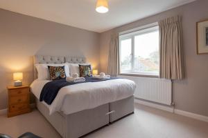 a bedroom with a large bed and a window at Buntings in Walberswick