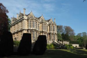 an old mansion with trees in front of it at The Hall Estate - Historic Grade I-listed Jacobean Mansion in Bradford on Avon +28 photos