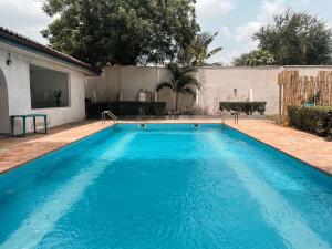 una gran piscina azul frente a una casa en Airport West 3BR apartment, en Accra