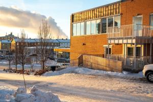 un bâtiment recouvert de neige devant lui dans l'établissement Guestly Homes - 3BR City Charm, à Piteå