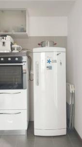 a white refrigerator in a kitchen next to a stove at Navigli House in Milan