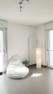 a white room with a bed and a plant at Navigli House in Milan