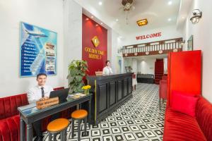 a man sitting at a counter in a restaurant at Golden Time Hostel 3 in Hanoi