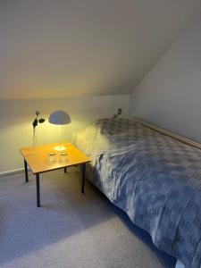 a bedroom with a bed and a table with a lamp at Kallerup Hgård in Thisted