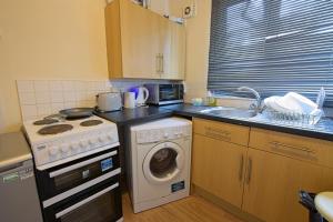 a kitchen with a stove and a washing machine at Stylish 1-Bed Apartment in Manchester