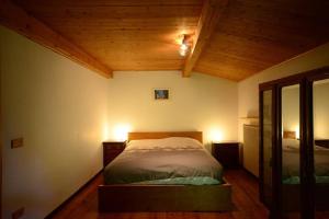a bedroom with a bed in a room with wooden ceilings at Meira Patoc in Frassino
