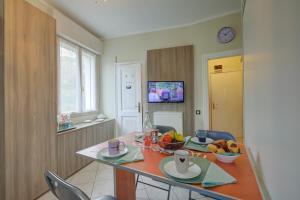 a dining room with a table with fruit on it at Aton House - Happy Rentals in Manerba del Garda