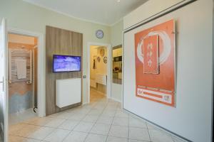 a hallway with a tv on a wall at Aton House - Happy Rentals in Manerba del Garda