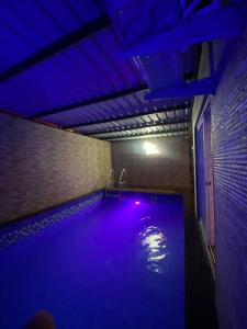 una piscina con luces azules en una habitación en Imagine star en Lonavala