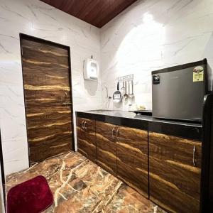 - une cuisine avec des portes en bois et un comptoir dans l'établissement Imagine star, à Lonavala