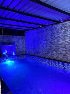 una piscina con luci blu in una stanza di Imagine star a Lonavala