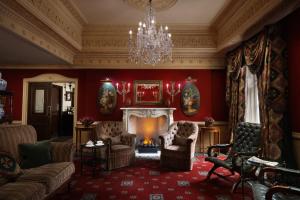 uma sala de estar com lareira e um lustre em The Montague On The Gardens em Londres