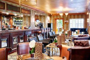 un restaurante con un bar con mesas y sillas de cuero en The Montague On The Gardens en Londres