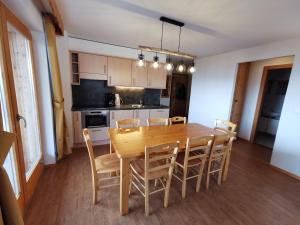 a kitchen and dining room with a wooden table and chairs at Pracondu OUTDOOR & FUN appartement 8 personnes by Alpvision Résidences in Nendaz