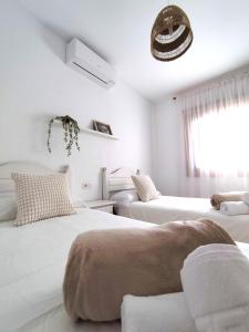 a white room with two beds and a window at Villas Rodríguez in Playa Blanca