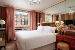 sypialnia z dużym białym łóżkiem i oknem w obiekcie The Montague On The Gardens w Londynie