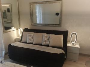 a bedroom with a black bed with a mirror and mirrors at JIMMYS HOUSE 55 in Beausoleil