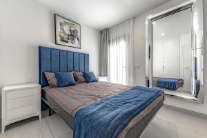 a bedroom with a large bed with a blue headboard at Luxury 2bedroom apartment on San Juan Beach in Playa de San Juan