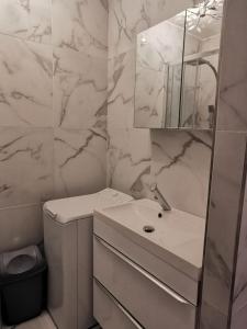 a white bathroom with a sink and a mirror at JIMMYS HOUSE 55 in Beausoleil