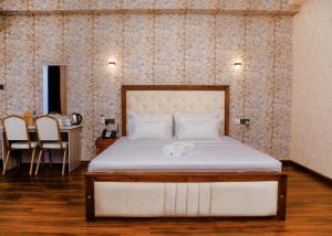 - une chambre avec un lit et une table avec des chaises dans l'établissement CROWN REGENCY- BADULLA, à Badulla