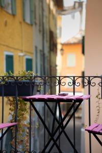 une table rose avec une plante en pot sur un balcon dans l'établissement Casa Canarino, à Riva del Garda