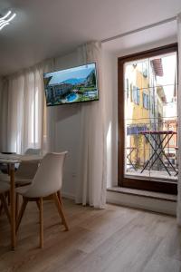 a living room with a table and a tv on the wall at Casa Canarino in Riva del Garda