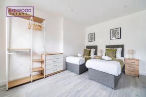 a bedroom with two beds and a dresser at Well-Equipped Serviced Apartments in Aldershot Town Centre, Free WiFi By Redwood Stays in Aldershot