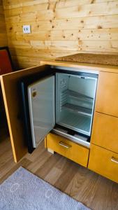 an open refrigerator in a wooden cabinet in a kitchen at Rosa&Vera in Ucea de Sus