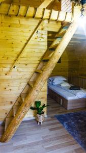 een zolderkamer met een bed in een houten plafond bij Rosa&Vera in Ucea de Sus